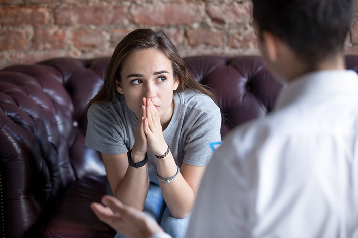 Concerned woman looking away while listening to psychologist